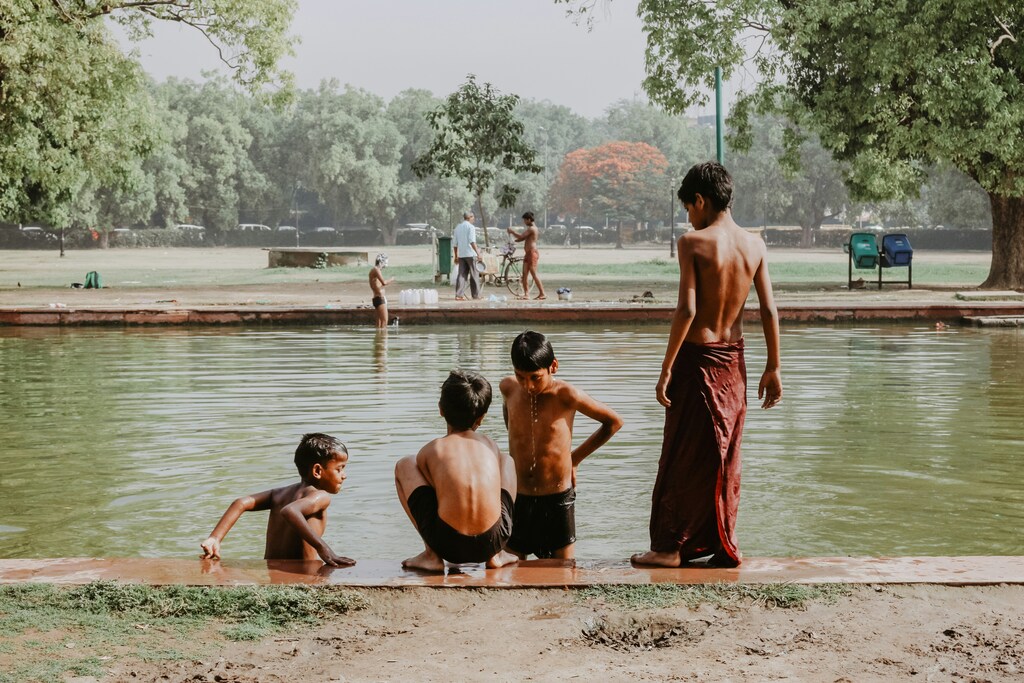 Four young boys bathe in a river new India gate, Delhi: Extreme heat impacts the vulnerable the most – a One Health approach is needed.