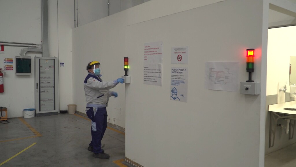 A worker is seen by a traffic light limiting the access to bathrooms inside the ISA factory that has introduced new safety measures to respect social distancing among workers to stop the spread of the coronavirus disease (COVID-19) in Bastia Umbra, Italy, April 22, 2020, in this still image taken from video. REUTERS TV via REUTERS - RC2BAG9Z9LJB