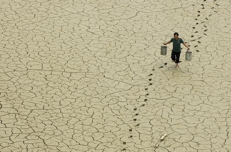 A farmer walks on a dried-up pond on the outskirts of Baokang, central China's Hubei province, June 10, 2007.