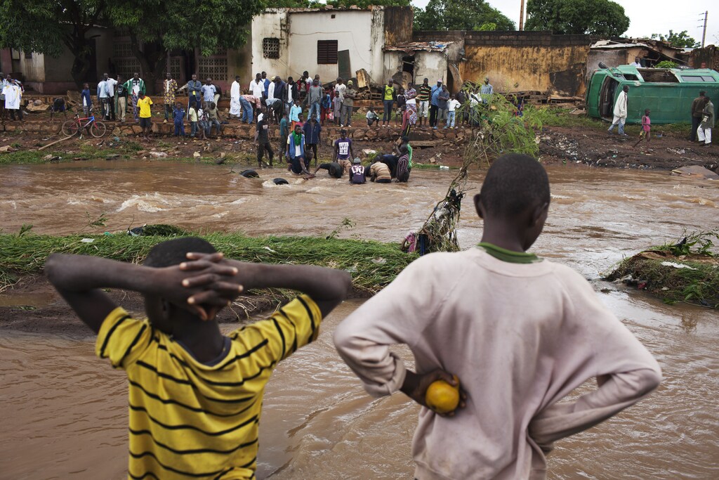 Boys survey the damage caused by floodwaters in Bamako August 29, 2013. Twenty-four people were killed in Mali's riverside capital Bamako on Wednesday when torrential rains provoked flash floods that washed away homes in several neighbourhoods, a government minister said. RECould green accountability help communities in places like Mali, which are already experiencing catastrophic effects of climate change?UTERS/Joe Penney (MALI - Tags: DISASTER ENVIRONMENT). green accountability