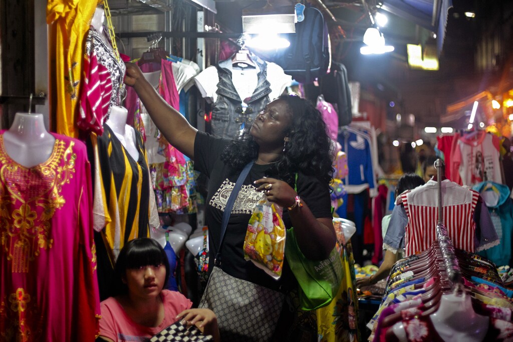 An African woman shops at a market at "African village" in Guangzhou, Guangdong province, October 25, 2014. Chinese authorities have identified the southern province of Guangdong, home to Asia's biggest African population, as a frontline in their efforts to prevent the deadly Ebola virus from entering mainland China. Picture taken October 25, 2014. REUTERS/Alex Lee (CHINA - Tags: HEALTH BUSINESS POLITICS DISASTER) - GM1EAAU1L6M01