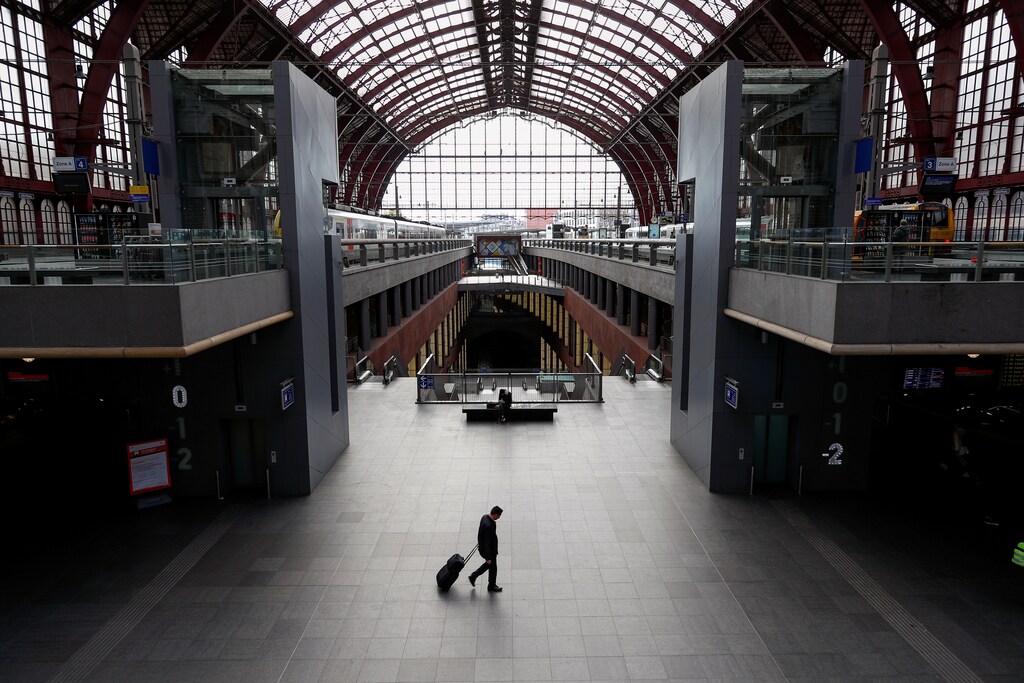 A man walks with his luggage through the almost empty railway station, after Belgium imposed a lockdown to slow down the spread of the coronavirus disease (COVID-19), in Antwerp, Belgium March 18, 2020. REUTERS/Francois Lenoir TPX IMAGES OF THE DAY - RC2CMF9IZEPF