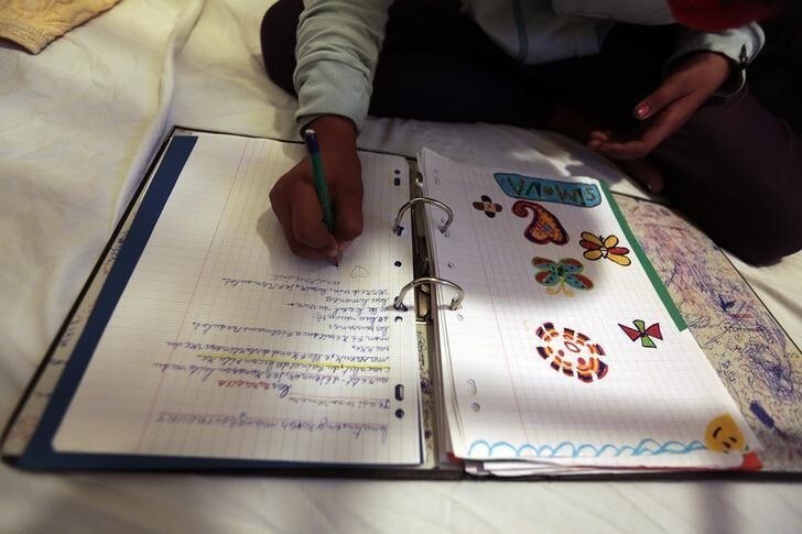 Simona, an 11 year-old Roma schoolgirl who has been living in France for 6 years, does her homework in an hotel in the centre of Nice, southeastern France, November 22, 2013. About fifty migrants from Romania were evicted from an illegal camp on November 27, 2013 where they had been living for 5 months. Six families with school-age children have received emergency housing at an hotel in Nice, as they wait for council housing. The other families have left the encampment with their belongings and will ask for a repatriation grant to Romania. Picture taken November 22, 2013. REUTERS/Eric Gaillard (FRANCE - Tags: POLITICS SOCIETY IMMIGRATION EDUCATION)