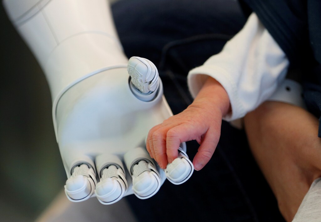 New recruit "Pepper" the robot, a humanoid robot designed to welcome and take care of visitors and patients, holds the hand of a new born baby at AZ Damiaan hospital in Ostend, Belgium June 16, 2016.
