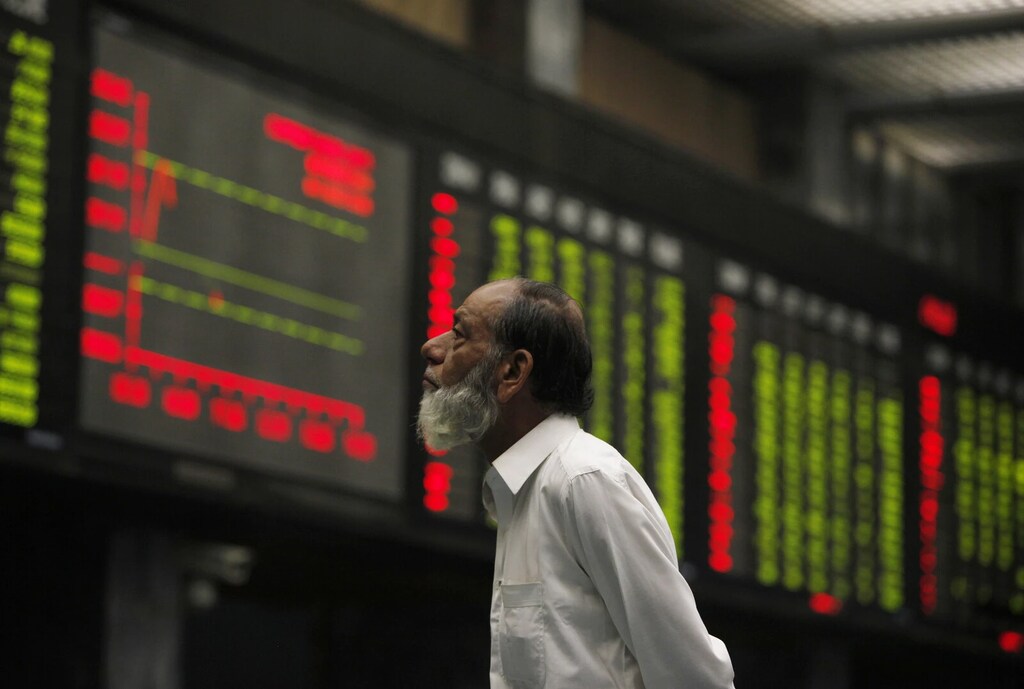 Un corredor supervisa un tablero electrónico que muestra los precios de las acciones durante una sesión de negociación en la Bolsa de Karachi el 16 de octubre de 2014. El acceso al crédito permite tanto a particulares como a empresas fijarse objetivos financieros a largo plazo.