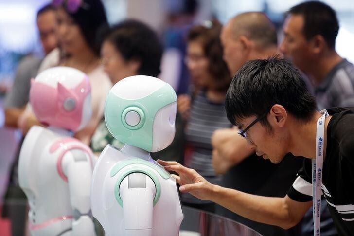 A man programs an iPal Companion Robot by Nanjing Avatar Mind Robot Technology at the 2017 World Robot conference in Beijing, China August 22, 2017. REUTERS/Thomas Peter