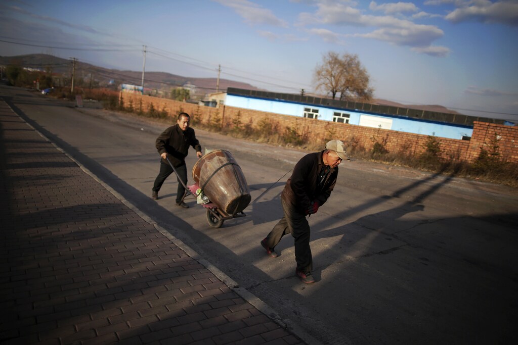Miners carry their supplies for upcoming winter, towards a coal mine from the state-owned Longmay Group, on the outskirts of Jixi, in Heilongjiang province, China, October 24, 2015. To match story CHINA-COAL/JIXI Picture taken on October 24, 2015. REUTERS/Jason Lee - GF20000045470