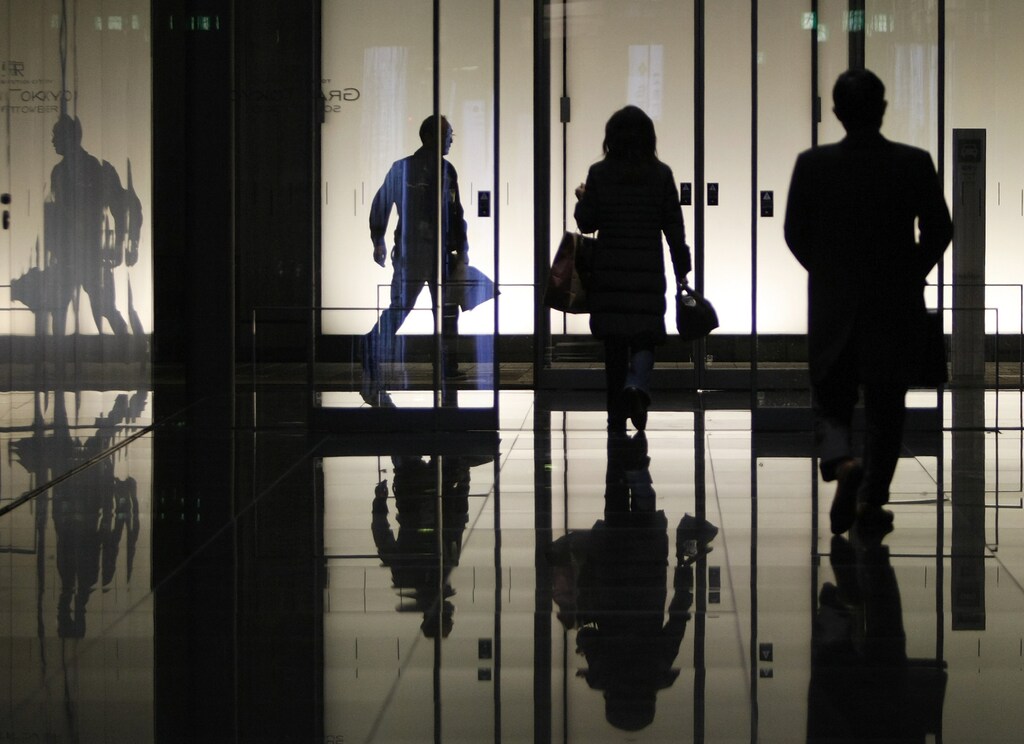Pedestrians walk through an office building in Tokyo January 8, 2009. Deepening economic problems are forcing the government to prioritise spending to support the economy rather than steps to restore its tattered finances. REUTERS/Yuriko Nakao(JAPAN) - GM1E5181FTI01