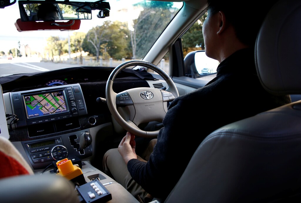 A worker of ZMP leaves his hands under the steering wheel in a RoboCar while the autonomous car makes its way during its demonstration in Tokyo, Japan, January 31, 2017. Picture taken on January 31, 2017. REUTERS/Kim Kyung-Hoon - RTX2ZFGA