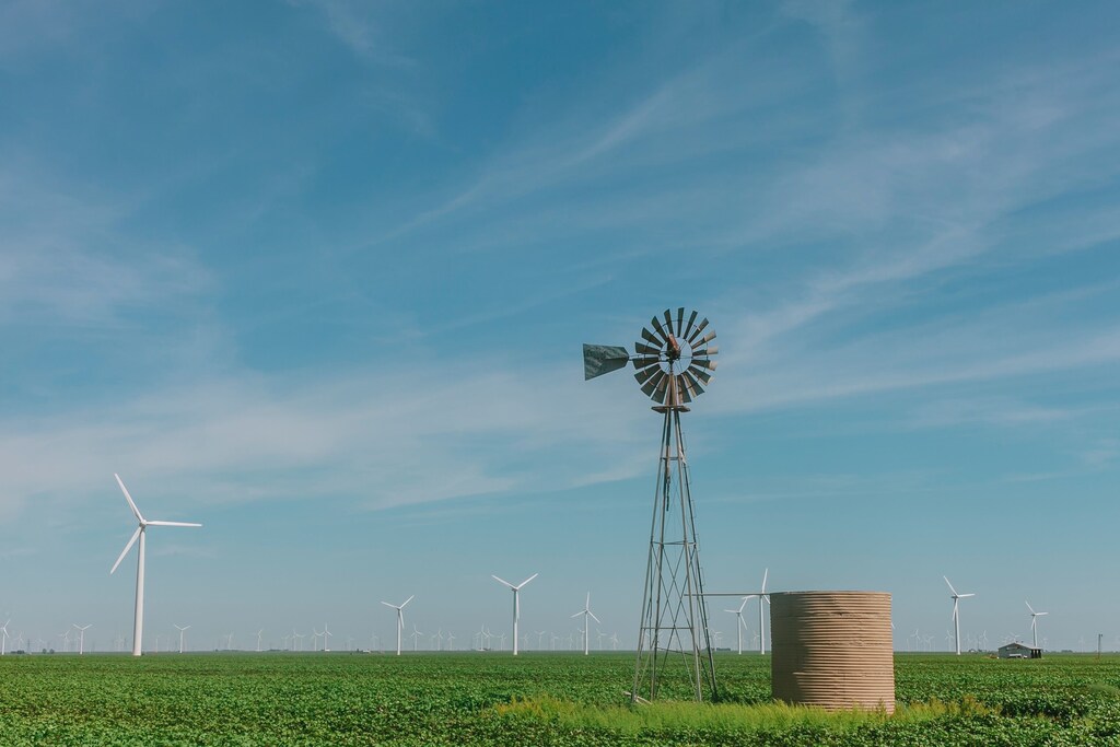 wind vane on grass field wind power turbine renewable clean air blue sky future green