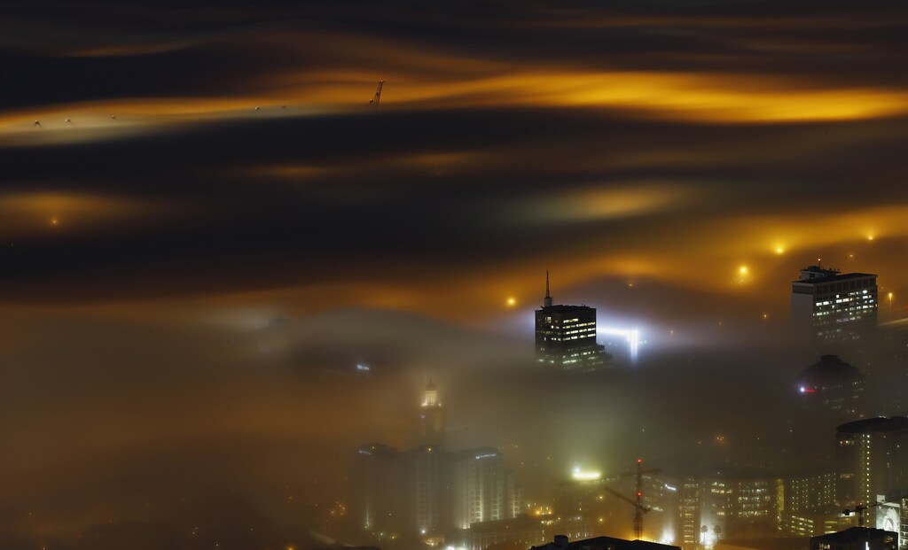 A long exposure picture shows a seasonal fog illuminated by the lights of Cape Town harbour