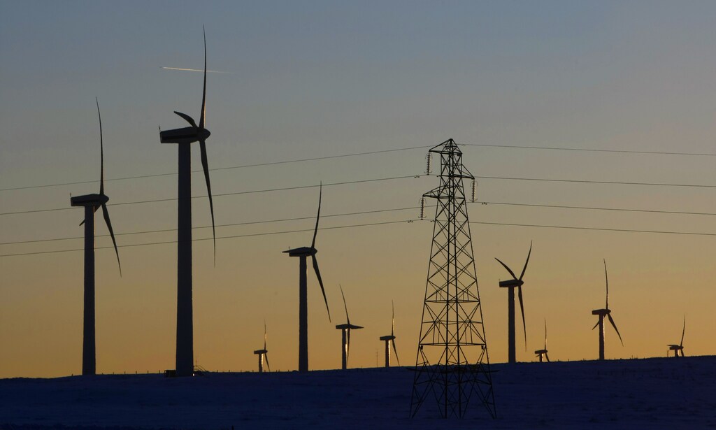 Electricity pylons and wind turbines are silhouetted at the Scottish Power-owned Dun Law West wind farm near Edinburgh, Scotland January 8, 2010. Britain has awarded energy companies the rights to develop the world's biggest offshore wind project in hopes the country will become a leader in the emerging industry, which is vital to slash carbon emissions. REUTERS/David Moir (BRITAIN BUSINESS - Tags: ENERGY ENVIRONMENT) - GM1E61906EW01