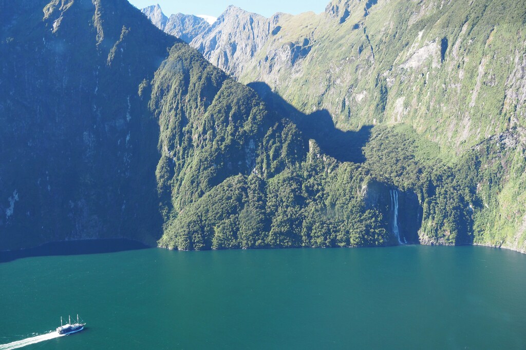 A cruise ship approaches a waterfall at Milford Sound New Zealand March 7, 2017. REUTERS/Henning Gloystein - RC1C70D0E700