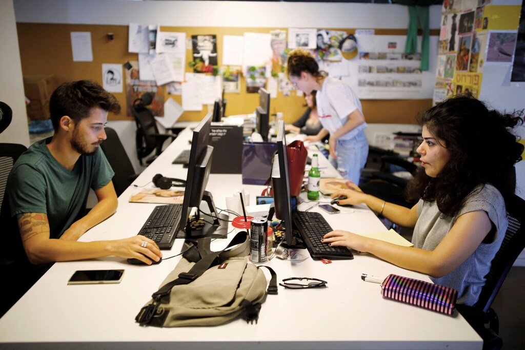 Employees work at the offices of "Time Out Tel Aviv" magazine in Tel Aviv, Israel September 28, 2017. Picture taken September 28, 2017. REUTERS/Amir Cohen - RC1C045AA690