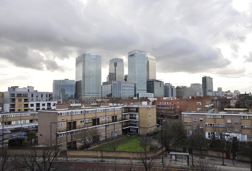 The buildings of the Canary Wharf financial district tower over Poplar, in East London March 27, 2010. Residents of the decaying Robin Hood Gardens estate, where grimy windows punctuate concrete, prison-like corridors, say they feel no connection with those living a short walk away in the luxury Canary Riverside complex. Photograph taken on March 27, 2010. REUTERS/Jas Lehal (BRITAIN - Tags: POLITICS ELECTIONS) - LM1E64C17KV01