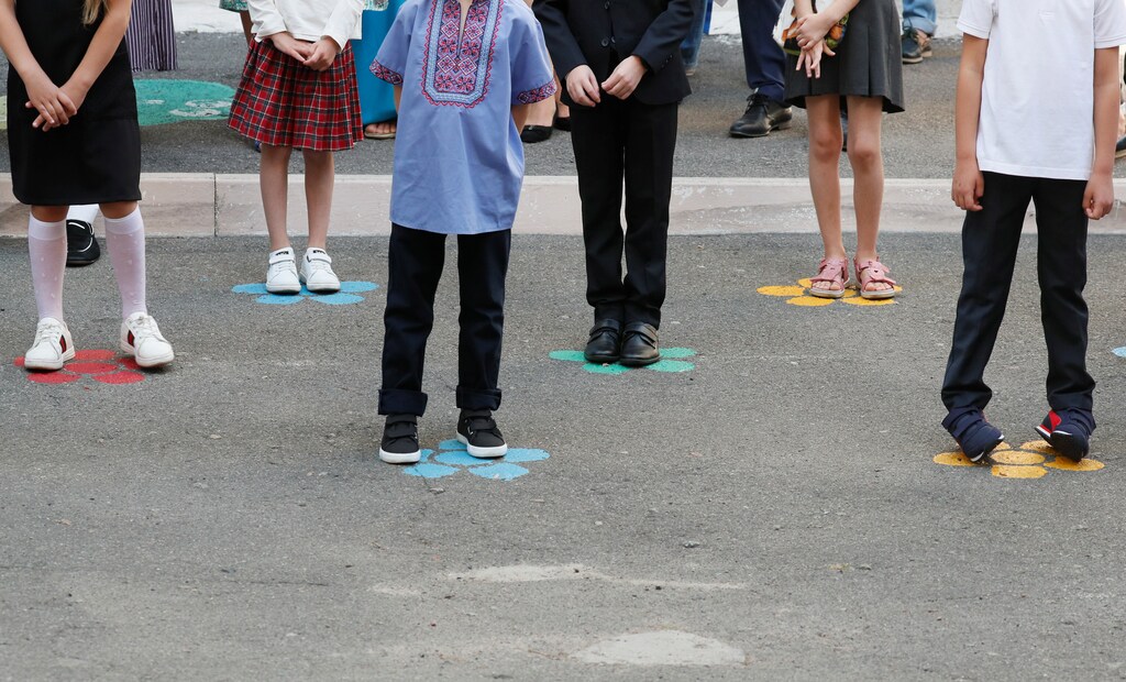 First graders stand on marks for social distancing during a ceremony to mark the start of the new school year, amid the outbreak of the coronavirus disease (COVID-19) in Kyiv, Ukraine September 1, 2020. REUTERS/ Gleb Garanich - RC2LPI9MVNTW