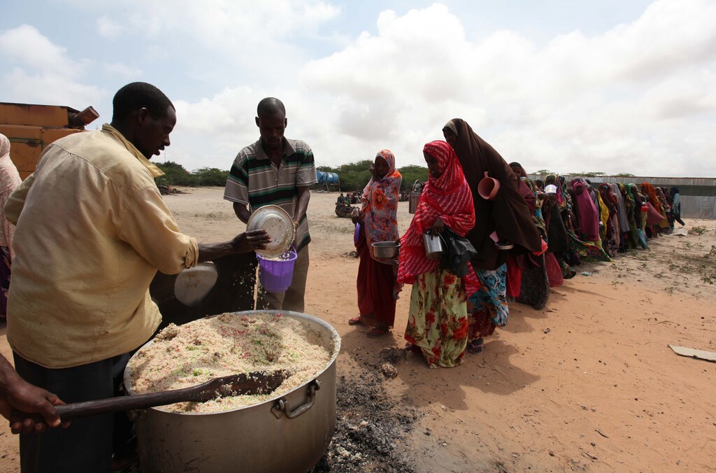 Internally displaced Somali people stand in a queue waiting to be served with cooked food in Hodan district south of capital Mogadishu September 5, 2011. Famine has spread to six out of eight regions in southern Somalia, with 750,000 people facing imminent starvation, the United Nations said on Monday, and hundreds of people are dying each day despite a ramping up of aid relief. REUTERS/Feisal Omar (SOMALIA - Tags: DISASTER ENVIRONMENT SOCIETY POVERTY FOOD) - GM1E7951TGM01