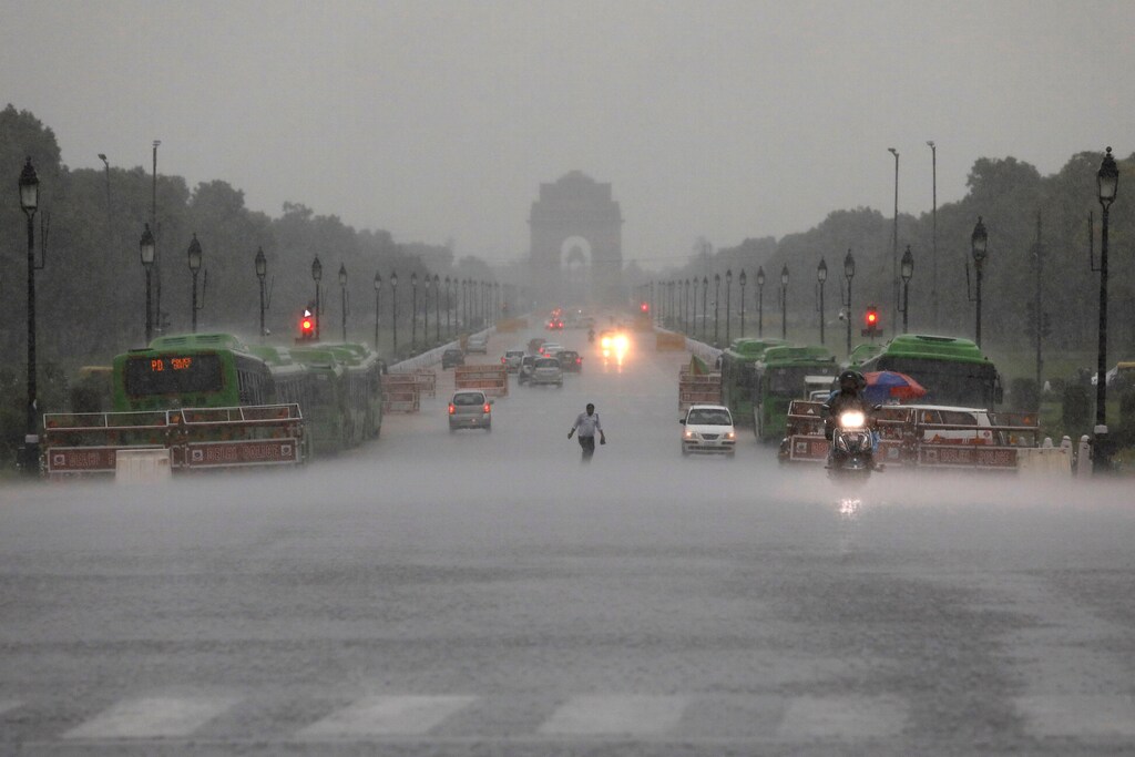 A man runs as he crosses a road near India Gate during heavy rains in New Delhi, India, August 6, 2019. REUTERS/Anushree Fadnavis TPX IMAGES OF THE DAY - RC1422AEA800