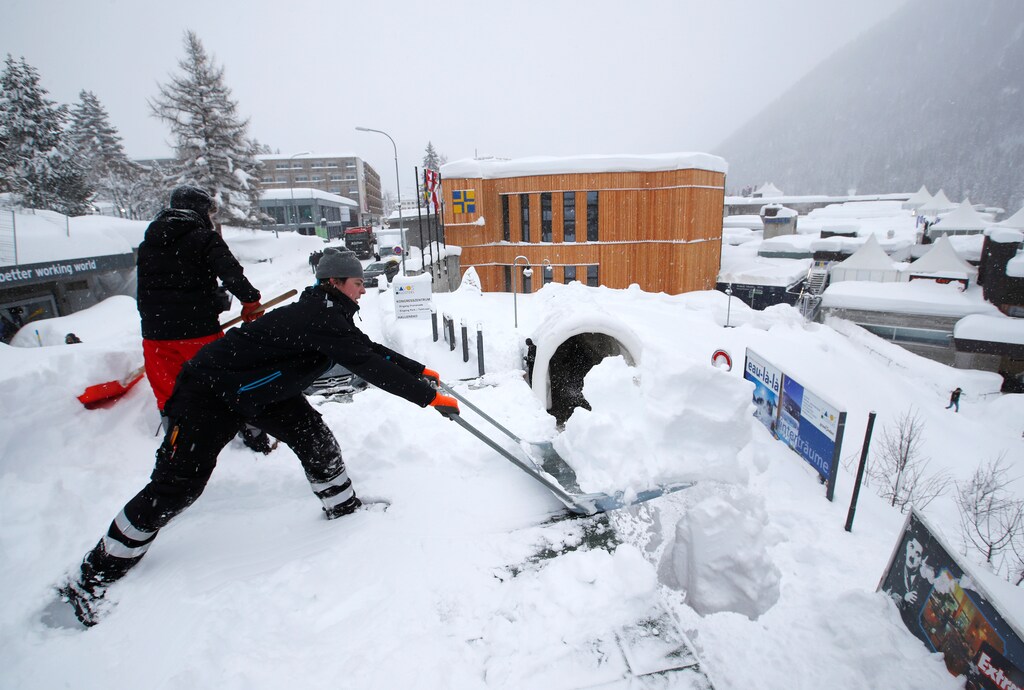 Staff clear snow ahead of the World Economic Forum's Annual Meeting, January 2018