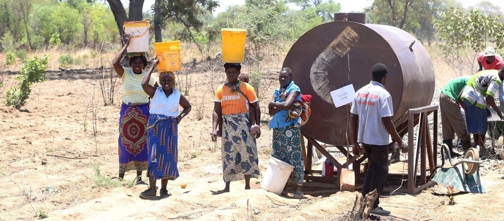 People fetching water from a water tank.