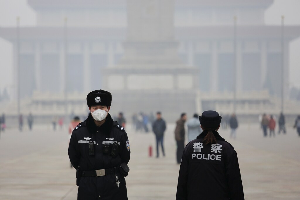Policemen wear masks protecting from extreme smog at the Tiananmen Square in Beijing December 8, 2015 as China's capital issues its first ever "red alert" for pollution. REUTERS/Damir Sagolj - GF10000258348