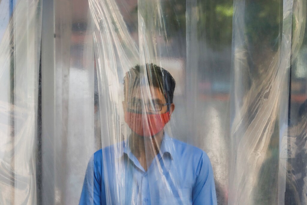 Un hombre usa una máscara protectora mientras se higieniza antes de entrar en un centro comercial, después de que Pakistán comenzara a suavizar las restricciones de cierre, en medio del brote de la enfermedad coronavirus (COVID-19), en Karachi, Pakistán, el 18 de mayo de 2020.