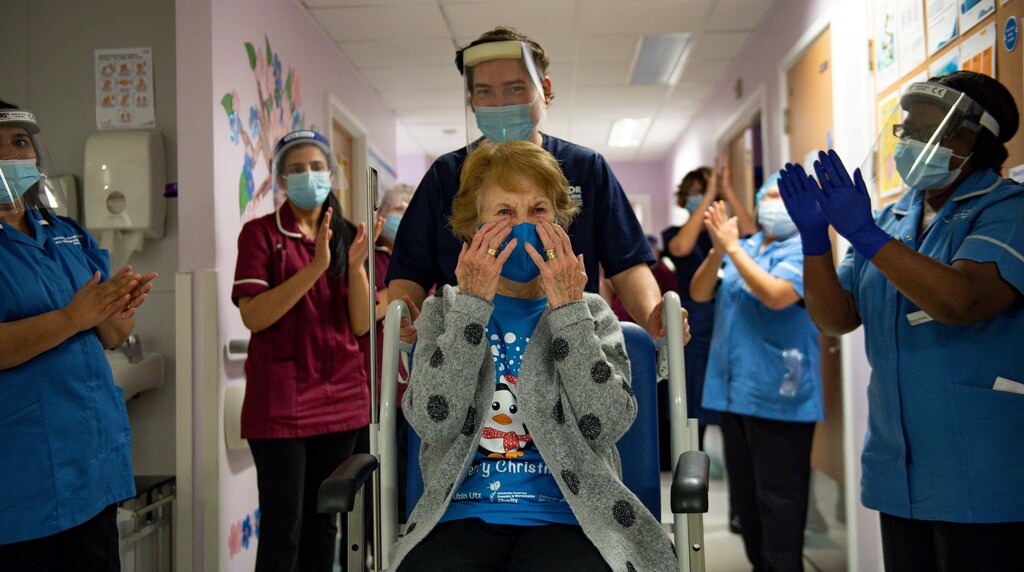 Margaret Keenan, 90, is applauded by staff as she returns to her ward after becoming the first person in Britain to receive the Pfizer/BioNTech COVID-19 vaccine at University Hospital, at the start of the largest ever immunisation programme in the British history, in Coventry, Britain December 8, 2020. Britain is the first country in the world to start vaccinating people with the Pfizer/BioNTech jab. Jacob King/Pool via REUTERS TPX IMAGES OF THE DAY - RC2XIK99JVEQ