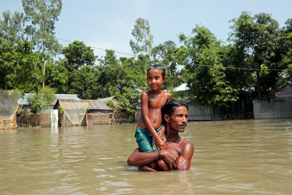 Flood-affected people wade through flooded water in Jamalpur, Bangladesh, July 21, 2019. REUTERS/Mohammad Ponir Hossain - RC196990A670