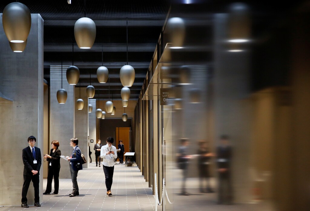 Employees of Fast Retailing Co., operator of Japan's Uniqlo clothing outlets, walk at the company's new headquarters building called UNIQLO CITY TOKYO, in Tokyo, Japan March 16, 2017. REUTERS/Issei Kato - RTX319I2