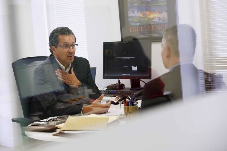 Leonardo Lacruz (L), the Venezuela director of multinational headhunter Korn/Ferry, talks to a man, during an interview at his office in Caracas August 3, 2015. Headhunters across Latin America are tapping Venezuela for low-cost professionals as a deepening economic crisis has left many skilled workers earning less money than taxi drivers and waiters. Highly-trained Venezuelans are seeking to escape a decaying socialist economy in which they often have to work second jobs and spend hours in line to buy basic goods such as milk or diapers. Picture taken on August 3, 2015. REUTERS/Carlos Garcia Rawlins
