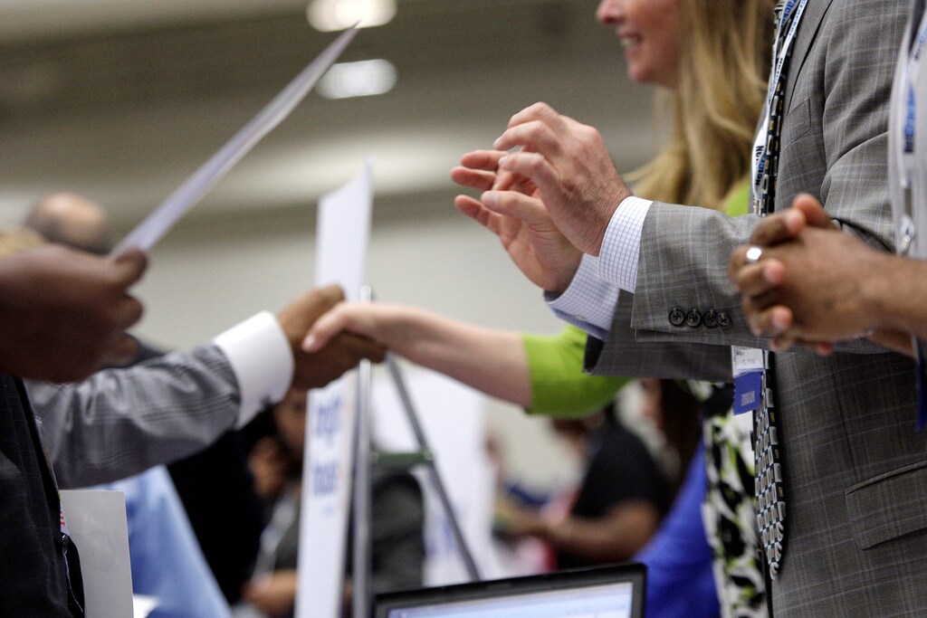 Corporate recruiters (R) gesture and shake hands as they talk with job seekers at a Hire Our Heroes job fair targeting unemployed military veterans and sponsored by the Cable Show, a cable television industry trade show in Washington, June 11, 2013. REUTERS/Jonathan Ernst/File Photo GLOBAL BUSINESS WEEK AHEAD PACKAGE SEARCH BUSINESS WEEK AHEAD 10 OCT FOR ALL IMAGES - RTSRJ2F