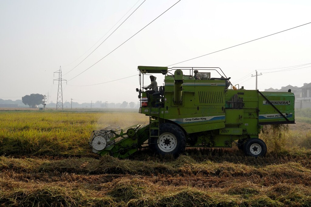 Un agricultor utiliza una cosechadora de arroz en un campo de cultivo en el estado de Haryana, India.
