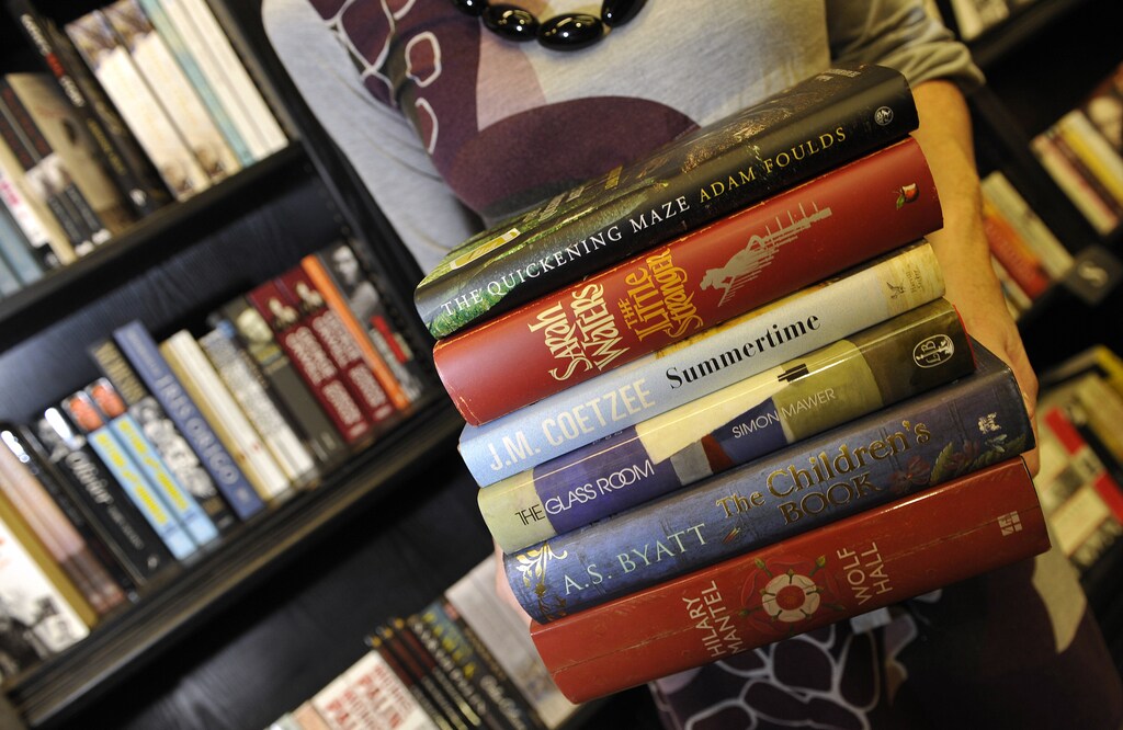An employee holds copies of the six shortlisted books for the Man Booker Prize as she poses for photographers in a bookshop in London October 5, 2009. The winner will be announced at the awards ceremony on Tuesday night.