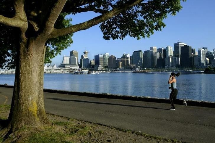A jogger runs along the seawall in Stanley Park with the city skyline in thebackground in this June 24, 2003 photo. Vancouver was named host of the 2010Winter Olympics during voting in Prague July 2, 2003. In a close vote theIOC gave the bid to Vancouver by a score 56 to 53 over Pyeongchang, SouthKorea. NO RIGHTS CLEARANCES OR PERMISSIONS ARE REQUIRED FOR THIS IMAGE REUTERS/Andy ClarkAC/AS