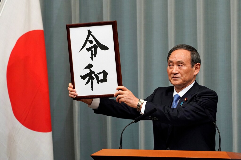 Japan's Chief Cabinet Secretary Yoshihide Suga unveils 'Reiwa' as the new era name at the prime minister's office in Tokyo, Japan, April 1, 2019. Franck Robichon/Pool via Reuters - RC118729F470