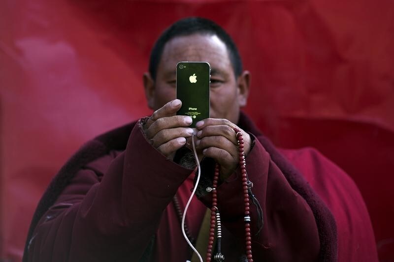 A Tibetan Buddhist monk takes pictures with his smartphone of a daily chanting session at a Buddhist laymen lodge during the Utmost Bliss Dharma Assembly, the last of the four Dharma assemblies at Larung Wuming Buddhist Institute in remote Sertar county, Garze Tibetan Autonomous Prefecture, Sichuan province, China early October 30, 2015. The eight-day gathering of people chanting mantras and listening to teachings of monks starts every year around the 22nd of the ninth month on Tibetan calendar, the great day of Buddha's Descending from Tushita Heavens. The Larung Wuming Buddhist Institute, located some 3700 to 4000 metres above the sea level was founded in 1980 by Khenpo Jigme Phuntsok, an influential lama of Nyingma sect of Tibetan buddhism with only around 30 students but is now widely known as one of the biggest centres to study Tibetan Buddhism in the world. Picture taken October 30, 2015. REUTERS/Damir Sagolj TPX IMAGES OF THE DAY - GF20000043731