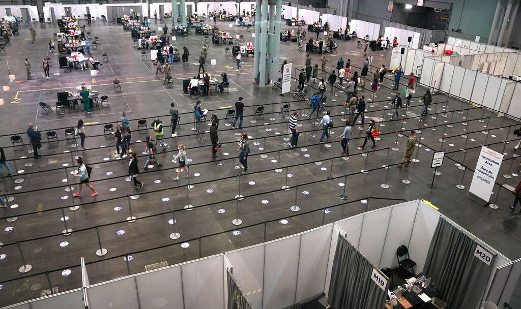 People stand in line at the Jacob K. Javits Convention Center Vaccination Center as Governor Andrew M. Cuomo announces the start of the statewide "Vaccinate NY" ad campaign to encourage all New Yorkers to get vaccinated, in New York City, New York, U.S. April 6, 2021. Timothy A. Clary/Pool via REUTERS - RC2LQM9MW1HD
