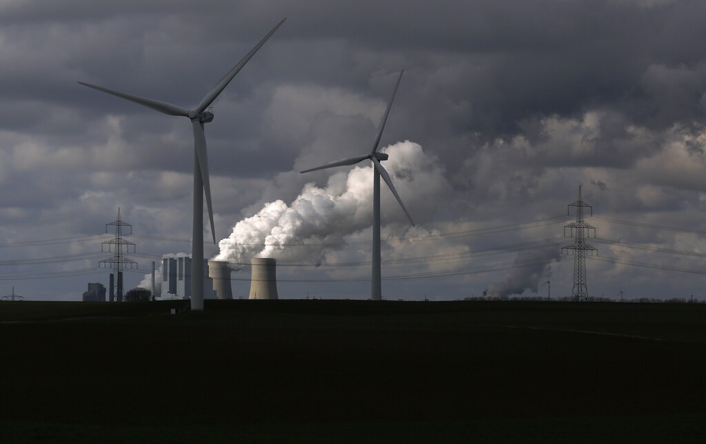 Wind turbines are seen in front of a coal power plant of German utility RWE Power near the western town of Neurath February 28, 2014.