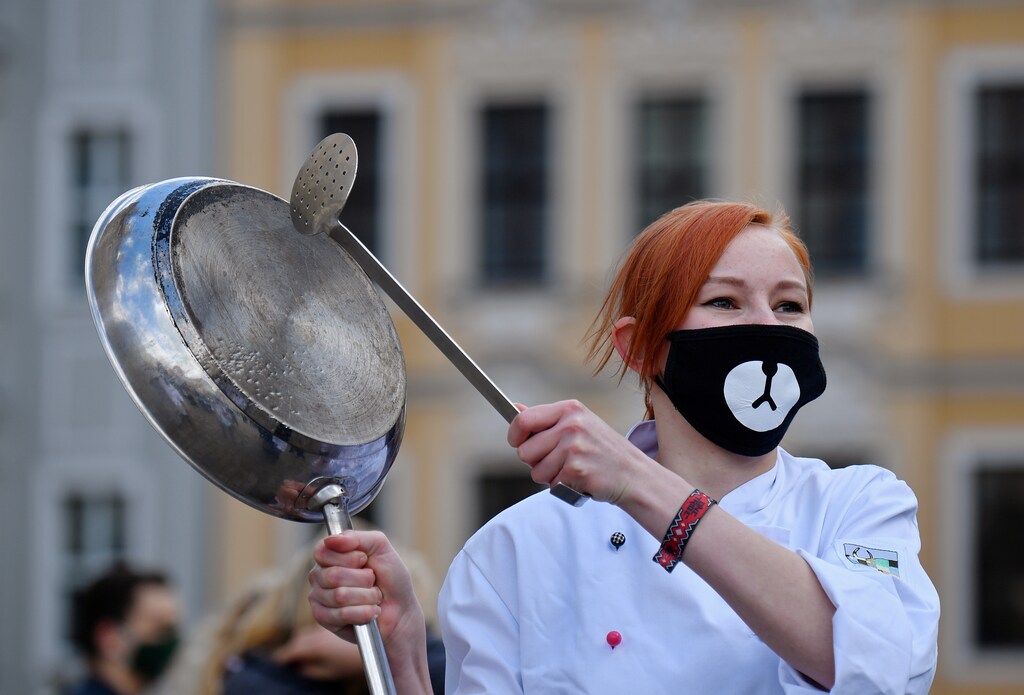 A restaurateur makes noise with a pan to call attention to the difficult situation of hotel and restaurant owners, as the spread of the coronavirus disease (COVID-19) continues in Dresden, Germany, May 1, 2020. REUTERS/Matthias Rietschel - RC2NFG96W7FU
