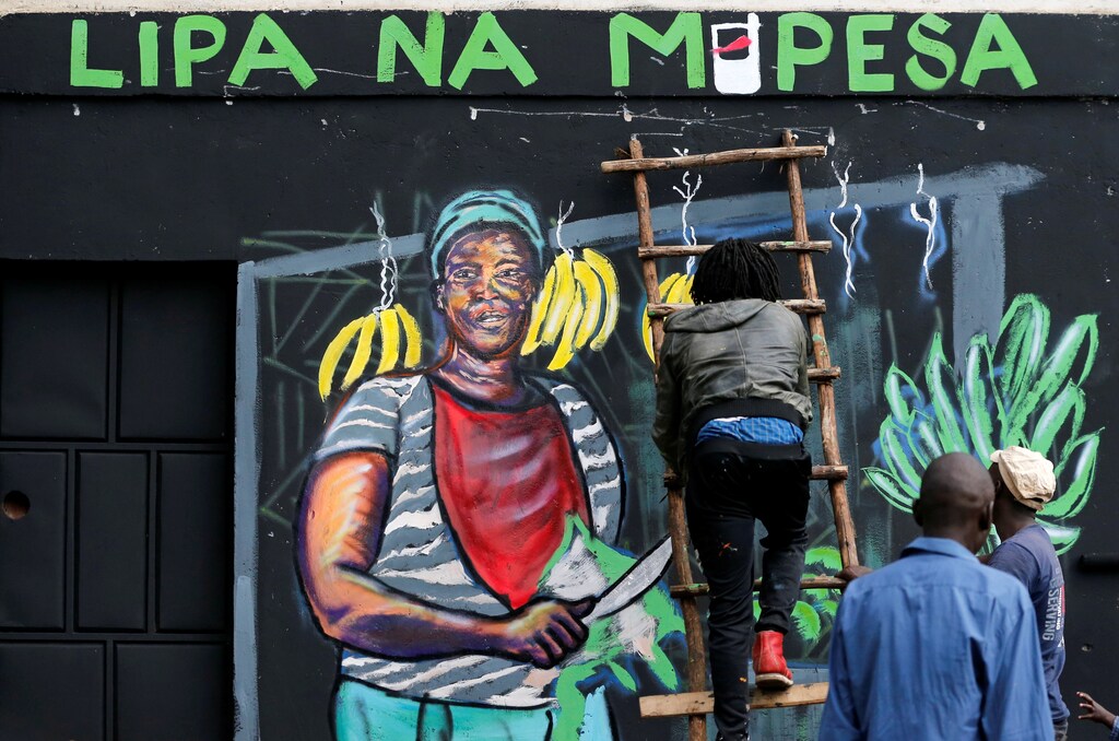 An artist works on a mural advocating for retail M-Pesa mobile phone cashless payments as a measure against the spread of the coronavirus disease (COVID-19) in Nairobi, Kenya April 19, 2020. Picture taken April 19, 2020. REUTERS/Thomas Mukoya - RC288G92R457