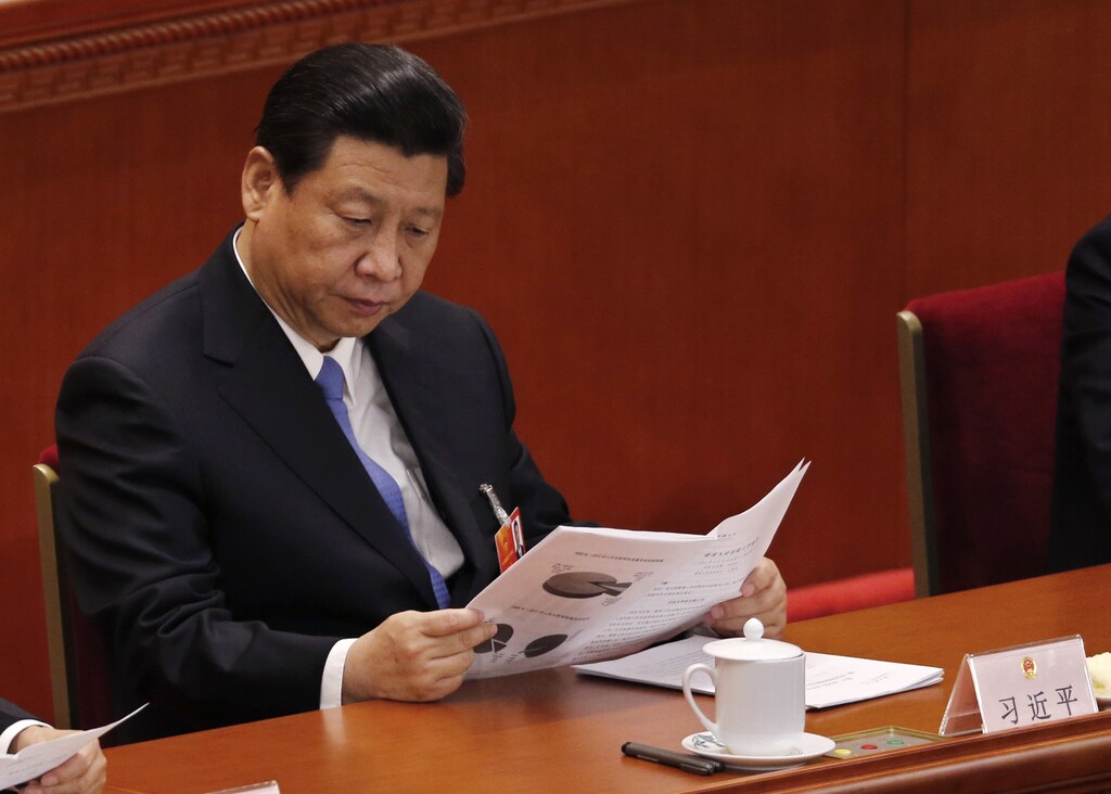 China's Communist Party Chief Xi Jinping reads at the Great Hall of the People during the third plenary session of the National People's Congress (NPC) in Beijing March 10, 2013.