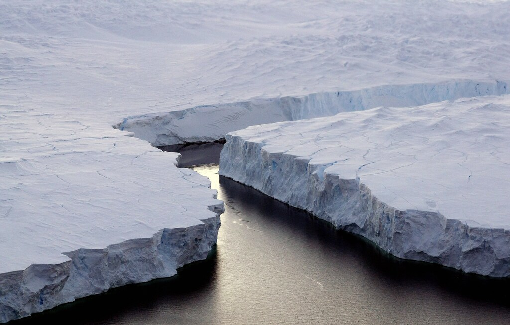 An enormous iceberg (R) breaks off the Knox Coast in the Australian Antarctic Territory, January 11, 2008. Australia's CSIRO's atmospheric research unit has found the world is warming faster than predicted by the United Nations' top climate change body, with harmful emissions exceeding worst-case estimates. Picture taken January 11, 2008. REUTERS/Torsten Blackwood/Pool (ANTARCTICA) - RTR1X0U1