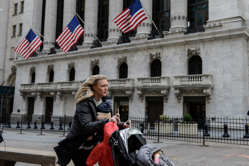 A woman pushes a stroller past the New York Stock Exchange on a windy day in New York City, U.S. February 13, 2017. REUTERS/Stephanie Keith - RC1F88463F80