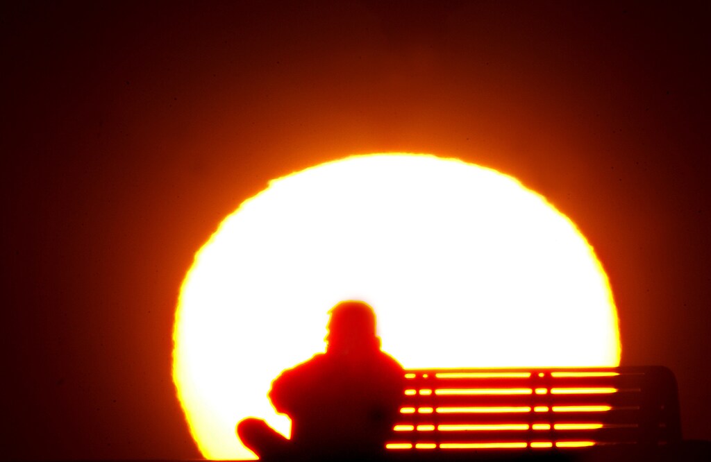 A man rests during sunset after a long and hot summer day at Dubai's popular Jumeirah beach May 10, 2005. The temperature has risen up to 40 degrees Celcius (104 degrees Fahrenheit) in various parts of the United Arab Emirates. REUTERS/Anwar Mirza AM/NL - RP6DRMSXMFAA