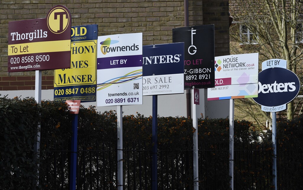 Property estate agent sales and letting signs are seen attached to railings in London, Britain, March 30, 2016. REUTERS/Toby Melville - RTSCYRG