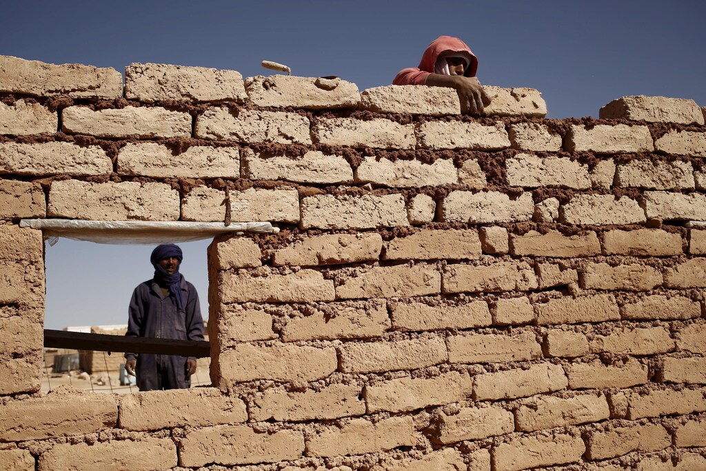 An indigenous Sahrawi man rebuilds his house, which was damaged by floods last October, in Al Smara desert refugee camp in Tindouf, southern Algeria March 4, 2016. In refugee camps near the town of Tindouf in arid southern Algeria, conditions are hard for indigenous Sahrawi residents. Residents use car batteries for electricity at night and depend on humanitarian aid to get by. The five camps near Tindouf are home to an estimated 165,000 Sahrawi refugees from the disputed region of Western Sahara, according to the United Nations refugee agency UNHCR. REUTERS/Zohra Bensemra SEARCH "THE WIDER IMAGE" FOR ALL STORIES Matching text ALGERIA-SAHARA/ - GF10000333467