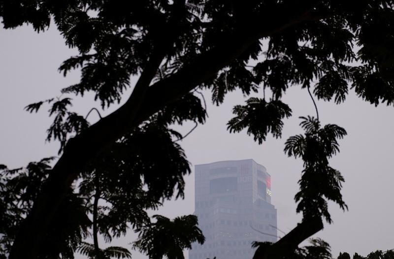 United Overseas Bank (UOB) Plaza skyscraper is seen amid trees during haze in Singapore, September 18, 2019. REUTERS/Kevin Lam - RC18AAC8A9C0