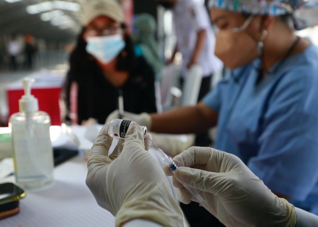 a healthcare worker prepares a dose of China's Sinovac Biotech vaccine against the coronavirus disease (COVID-19) during a mass vaccination program at a train station