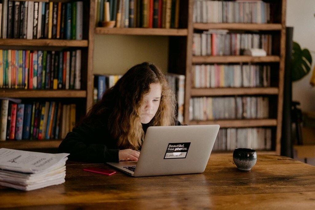 Young teen doing schoolwork at home after UK schools close due to the Coronavirus..