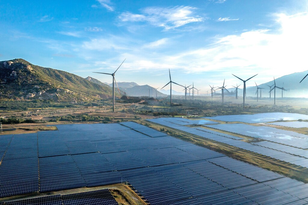 Wind turbines and solar panels are seen across the horizon.